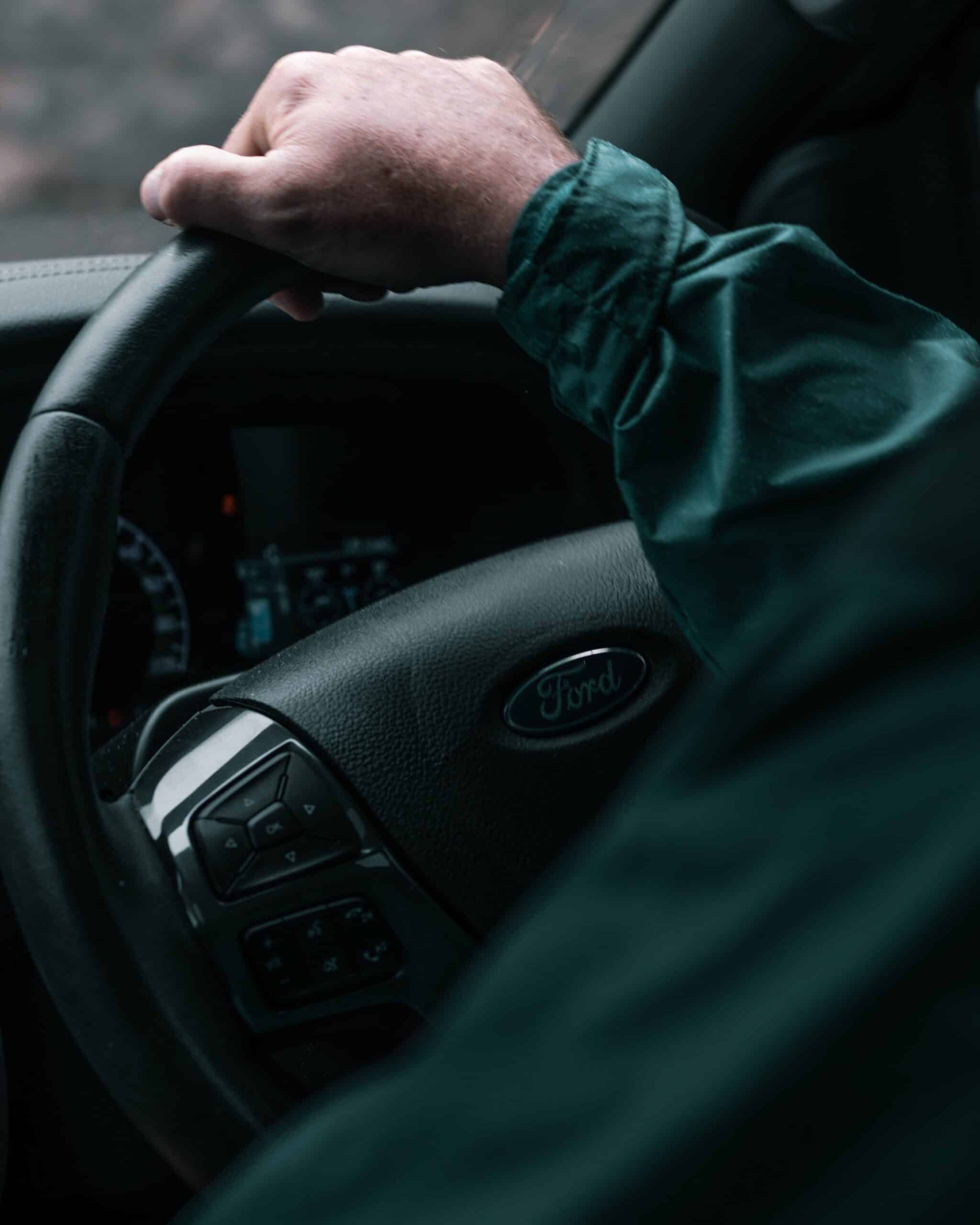 Security personnel driving a vehicle, close up of the steering wheel.